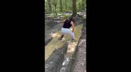 Mom struggles to stay upright in a deep and slippery mud puddle