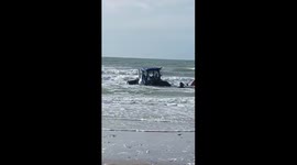 Tractor gets stuck in the sand. the rising water means the end of this tractor
