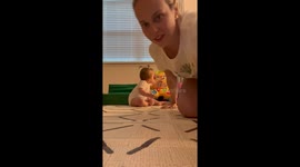 Mom uses selfie mode to inspire the baby girl to crawl and explore