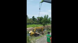 Workers hoist up excavator that sank during clearing operation