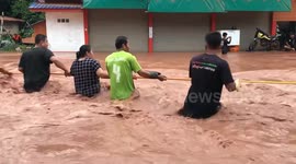 Residents cross flash flood on rope in Thailand