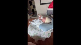 Clever newborn baby feeds himself with bottle