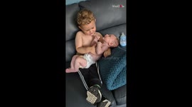 Toddler surprises when baby brother poos during their cuddling session