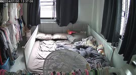 Toddler almost buried with clothes hanging on garment rack