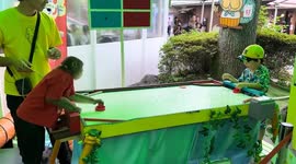 Monkey plays air hockey table with toddler