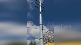 Policeman rescues man stuck 65ft up electricity tower