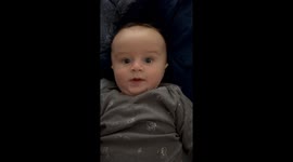 Baby gives parents funny shocked faces and when they we waves index cards by his face