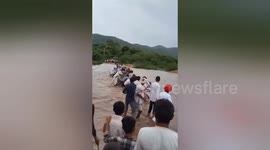 Residents form human chain to help goat herd cross raging river in western India