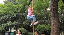 China: A Girl Climbs A Pole in Fuyang