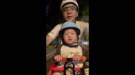 Father enjoys bike ride with son in China