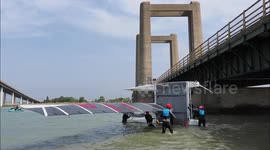 Competitors walk boats under Kingsferry Bridge in Kent's version of Round the Island Race, UK