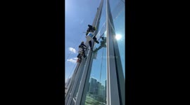 Don't look down! High rise window cleaner swings from 50th floor
