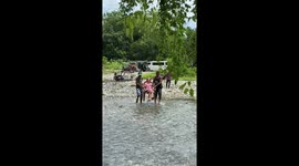 Kind neighbours carry grandmother across river