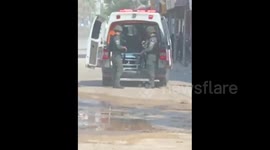 Israeli occupation soldiers inspecting a Palestine Red Crescent Society ambulance