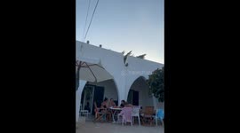 People drenched with water while dining outside in San Foca, Italy