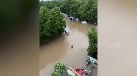 Deliveryman wades through flooded street to take meal to residents