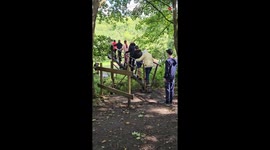 Elderly leader shows strength as the family crosses a tricky seesaw bridge together