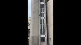 Commando lizard climbs up the side of university building