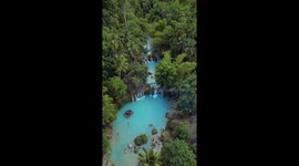 Aerial footage shows lush forest with blue river in the Philippines