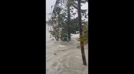 Boats floating through neighborhood, car completely being covered by water,