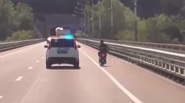 Crook on scooter tries to ram police patrol car off the road and is sent sprawling
