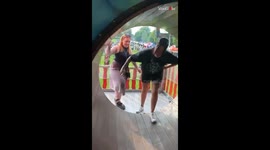 Woman loses balance right after stepping on funhouse wheel, drags friend with her too!