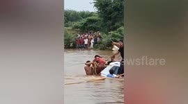Couple washed away by floods sit on top of car to be rescued
