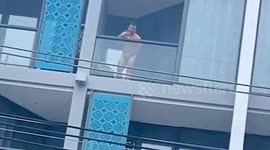 Tourist sparks outrage posing naked on balcony