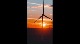 Wind turbines spin as sun sets in China's Xinjiang