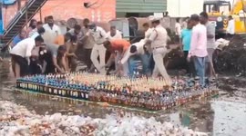 Locals steal illegal booze from under the nose of police preparing to destroy bottles