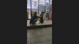 Homeless dog given affection by stranger outside shop