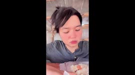 Cute cat pokes its head under worker's arm to check out her food