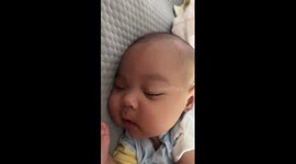 Baby smiles in sleep after hearing mother's laughter