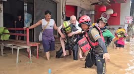 Rescuers carry pensioners to safety across floods in northern Thailand