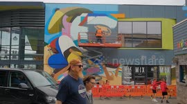 Cornwall's biggest Street Mural in creation, Artist Kleiner Shames on the platform. Newquay, Cornwall, UK