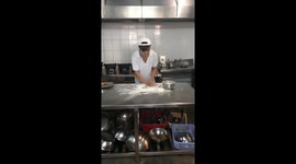 A friend of mine throwing pizza dough in the kitchen in his free time