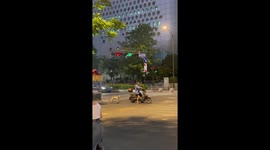 Motorcycle rider pulls his pet dog on a skateboard