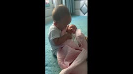 One-year-old boy cradles his newborn baby sister