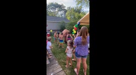 A hilarious moment at a children's birthday party as a man in a T. rex costume gets punched in the face twice by an enthusiastic 5-year-old!