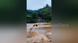Bicycle rider washed away by fast-flowing river rescued by locals