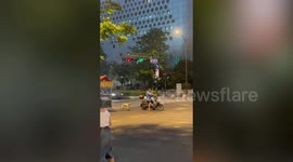 Scooter driver goes for a ride with pup trailing behind on skateboard