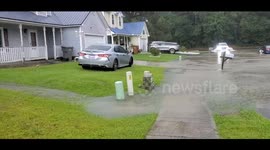 Car drives up on neighbors lawn to get around street flooding during a storm in Jacksonville North Carolina