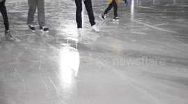 Skaters of all ages enjoying the freshly resurfaced ice at a neighborhood rink.