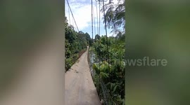 Suspension bridge snaps plunging six motorists into river in Indonesia