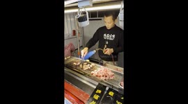 Street food seller energetically cooks steak with a blowtorch