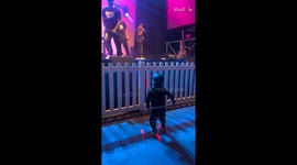 Little girl enthusiastically copies dad's dance moves during his live show performance