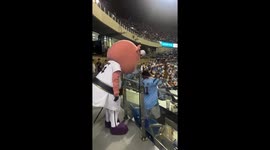 Baseball fan terrified by mascot looming behind him in stand