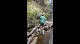 Person slips and falls on rocks near waterfall in Galicia, Spain
