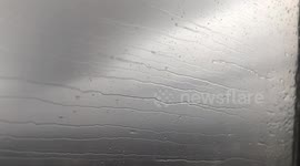 Beautiful ribbons of rain dance across airplane window