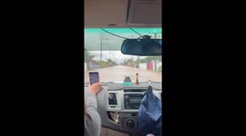 Family drive through flooded roads in northern Thailad